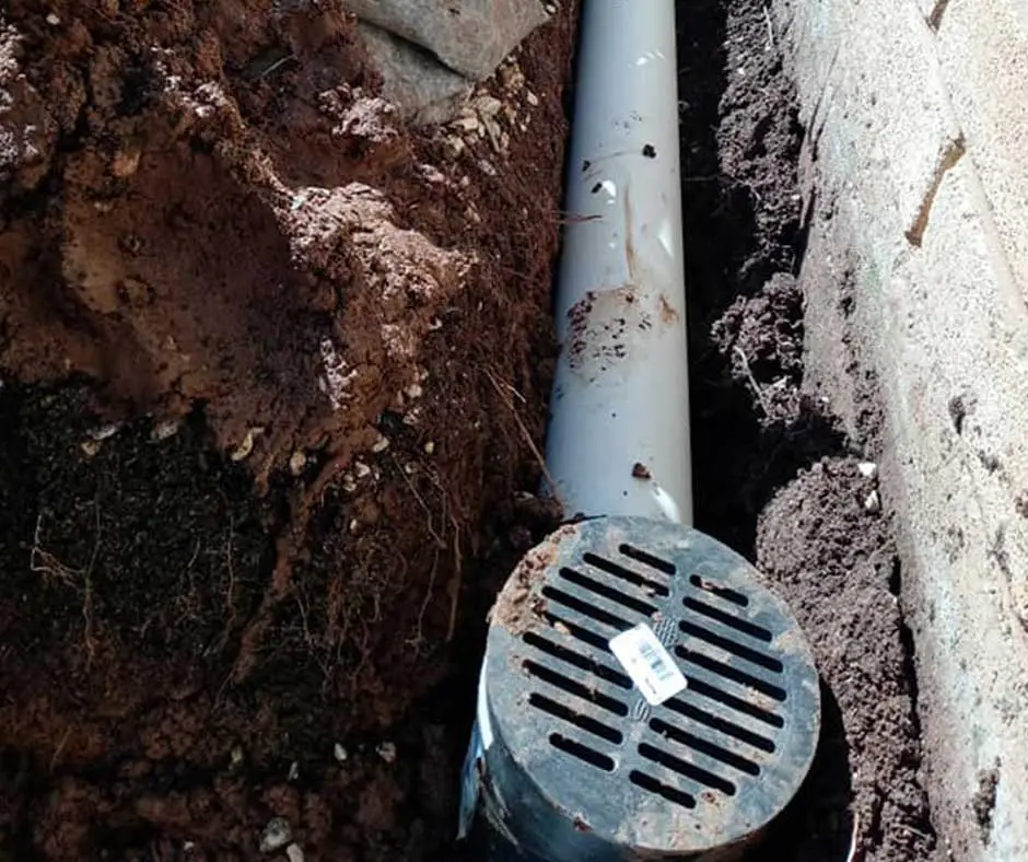 White drainage pipe with black grating French Drain Installation Philadelphia, PA